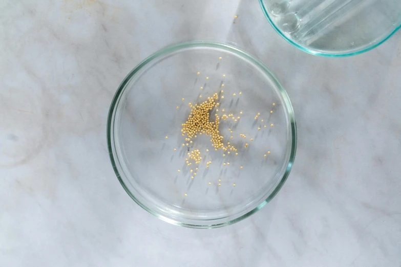 a bowl full of sand is next to another bowl with gold flakes on it