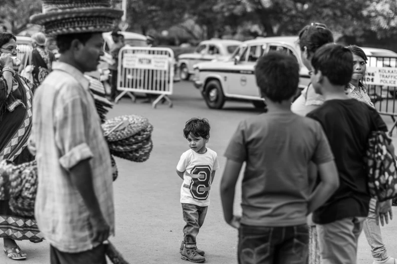 young children watching people move and talk in the street