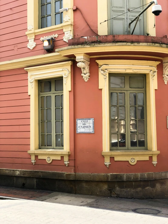 the building has many windows and is orange with a sign on it