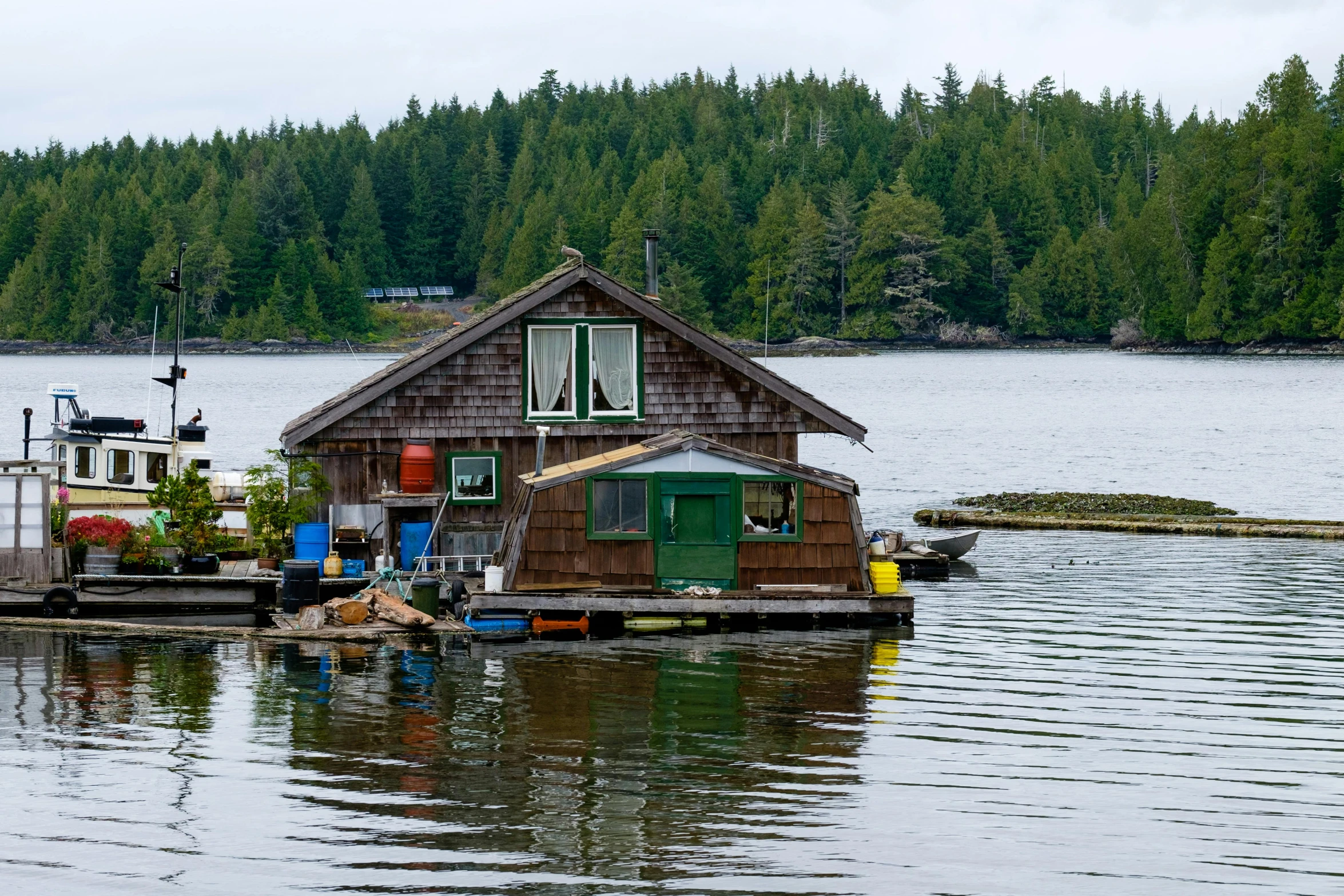 an outbuilding house floating on the water near boats