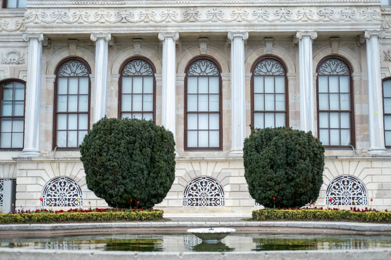 a building that has two statues of trees in front of it