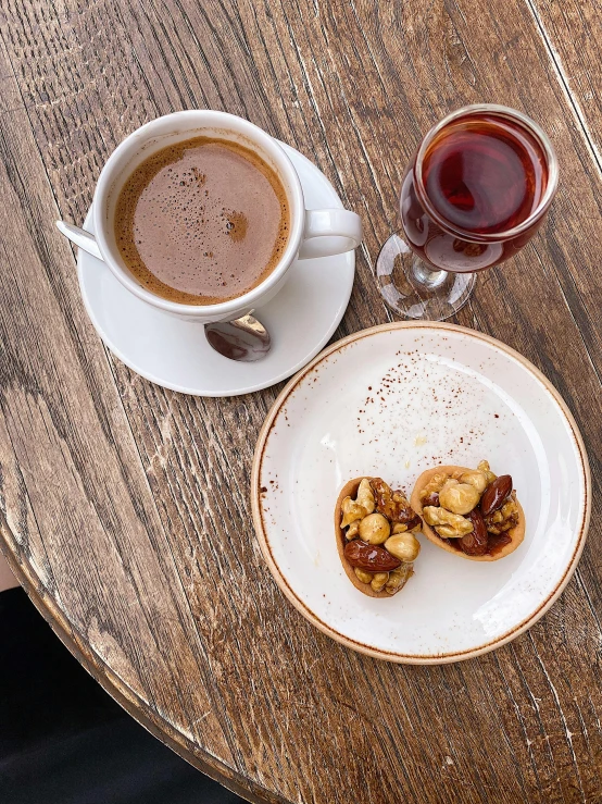 two cups of coffee and a plate with cookies on it