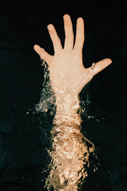 someones hand reaches up out from water