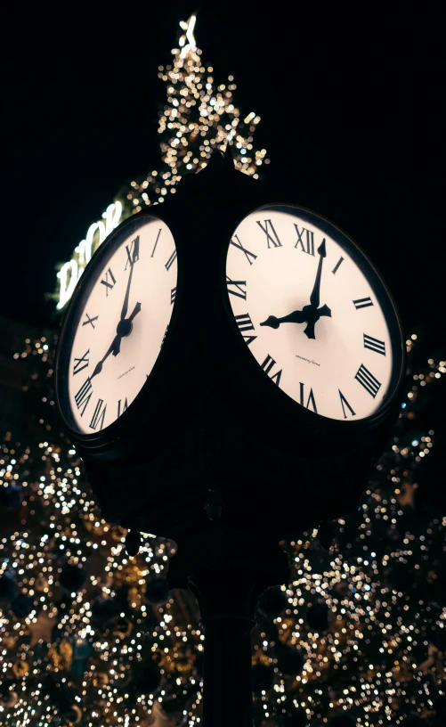 a clock with three faces at a nighttime event