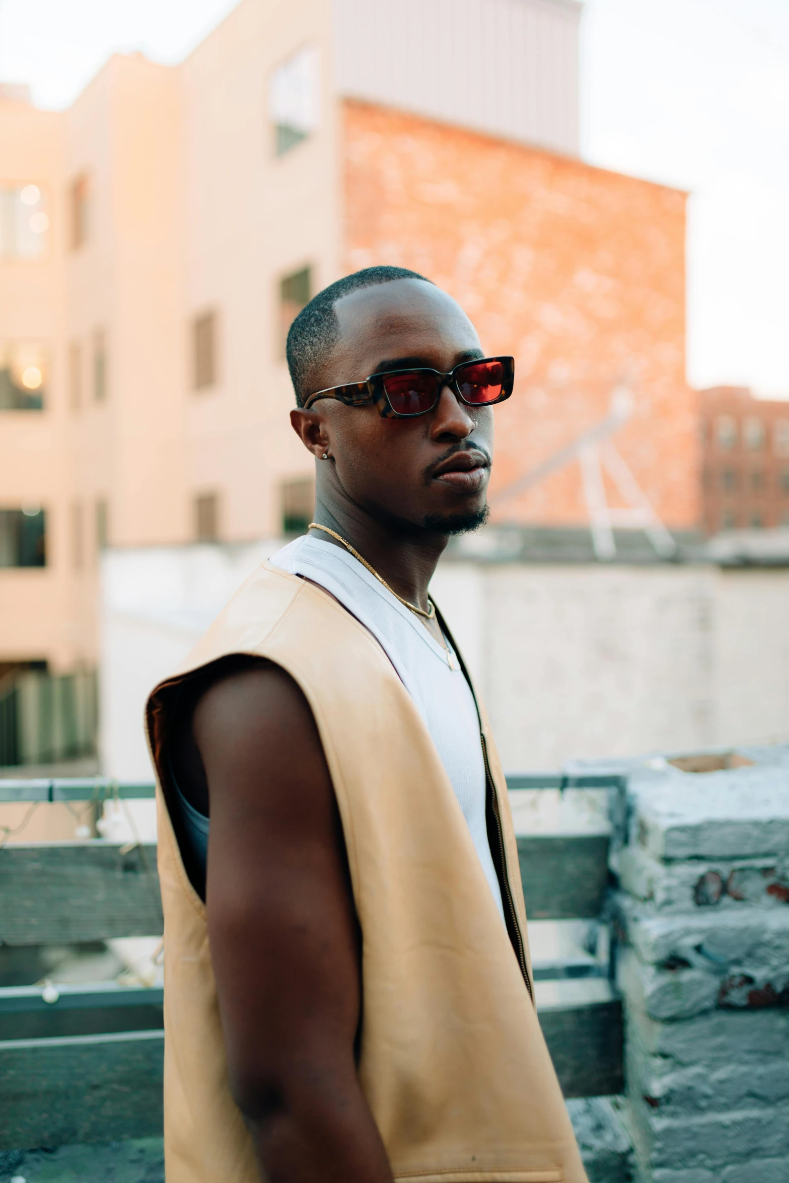 a man wearing sunglasses and a vest in the city