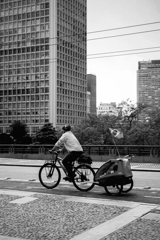 a person on a bicycle with a cart behind them