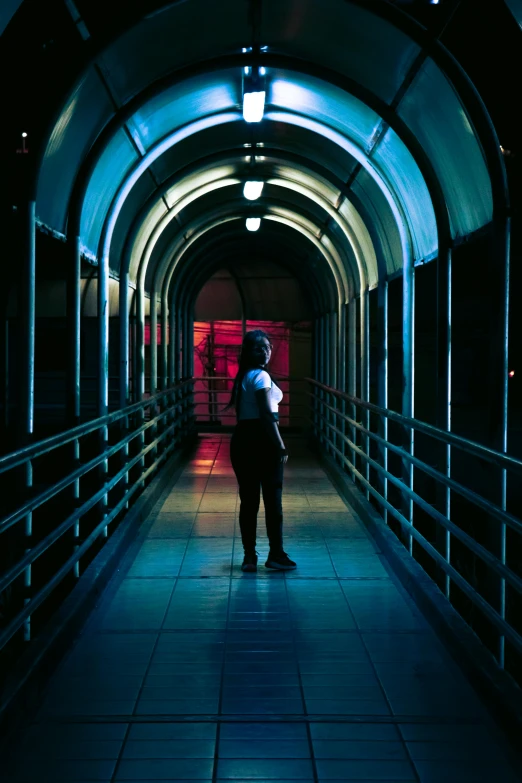 man standing alone in an overpass in a dark tunnel