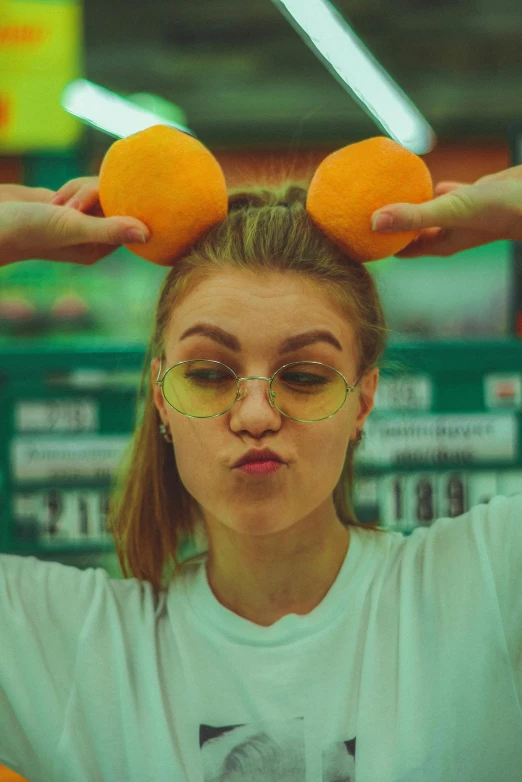 a girl in glasses is wearing oranges to her hair