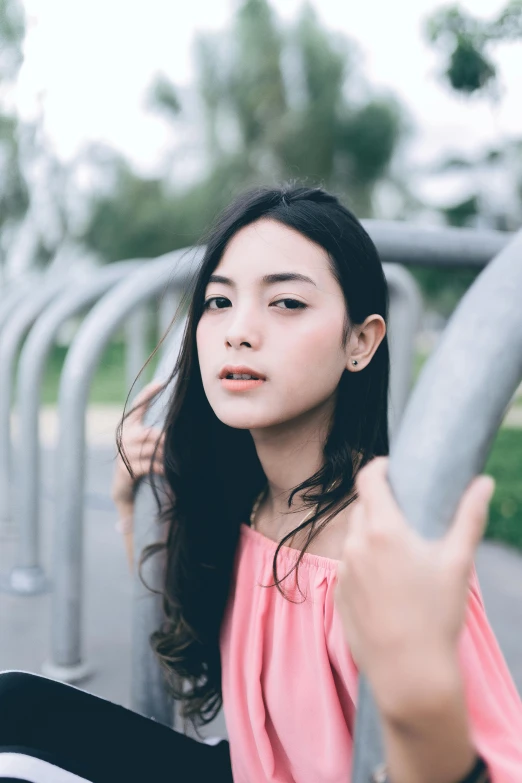 the girl is holding onto a grey metal rail