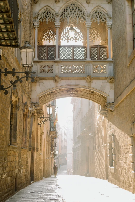 the light is shining in a street that has several arches