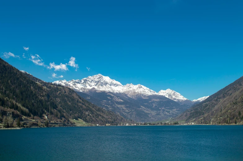 the mountains are covered with snow near the water