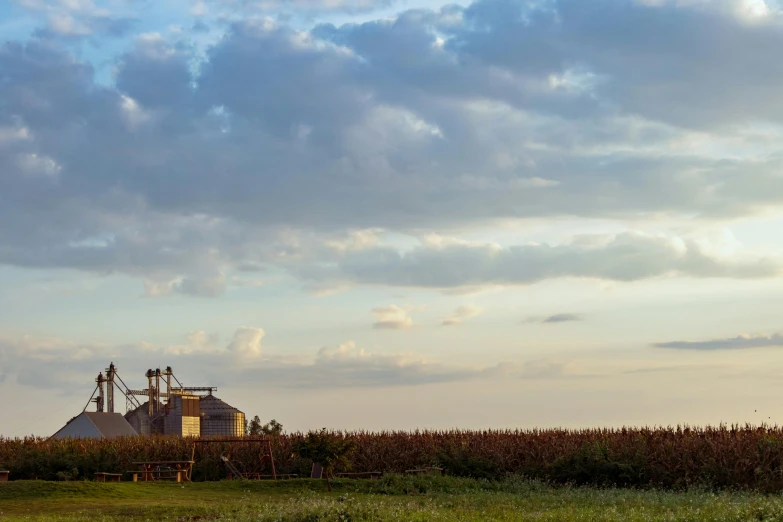 a field of grass and two buildings with chimneys