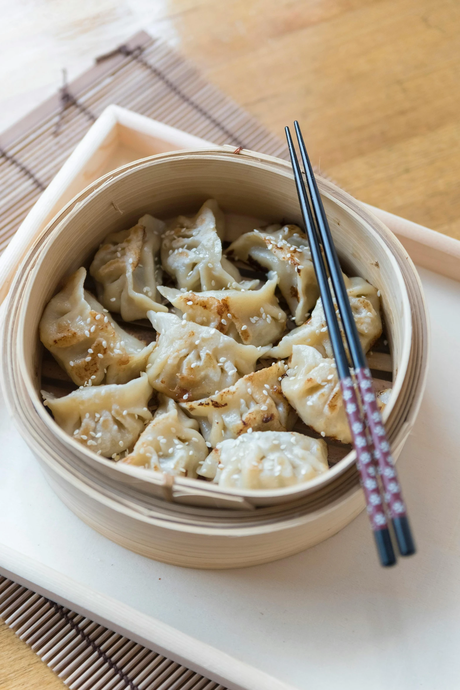 a bowl with some dumplings on top of it and chop sticks