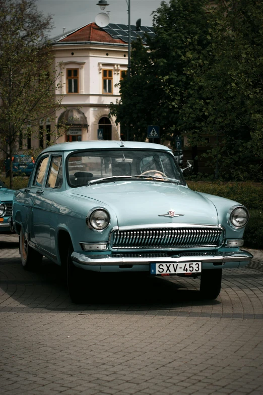 an old vintage car is parked in the street