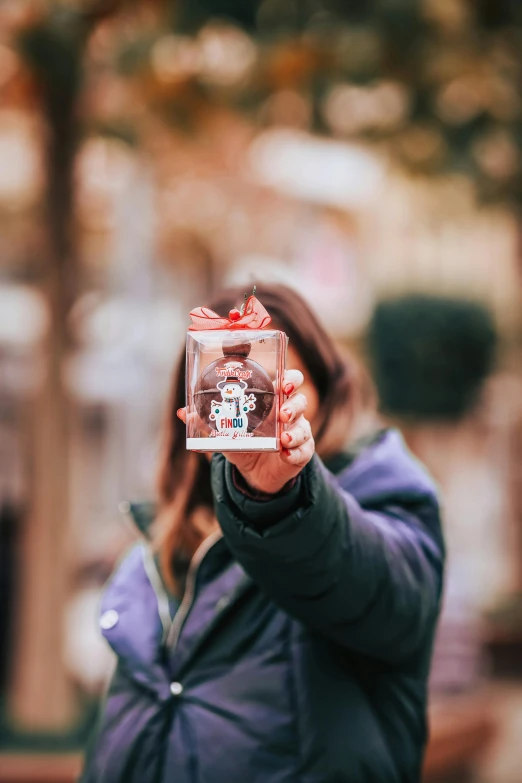 woman in blue jacket taking picture with cell phone