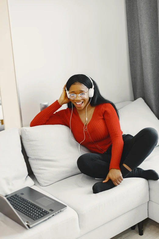 a woman in headphones sitting on top of a couch