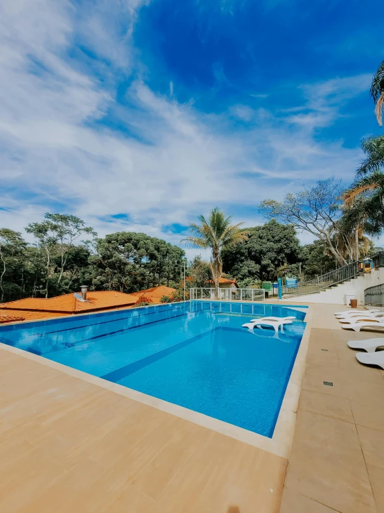 a pool in the shade with chairs by it