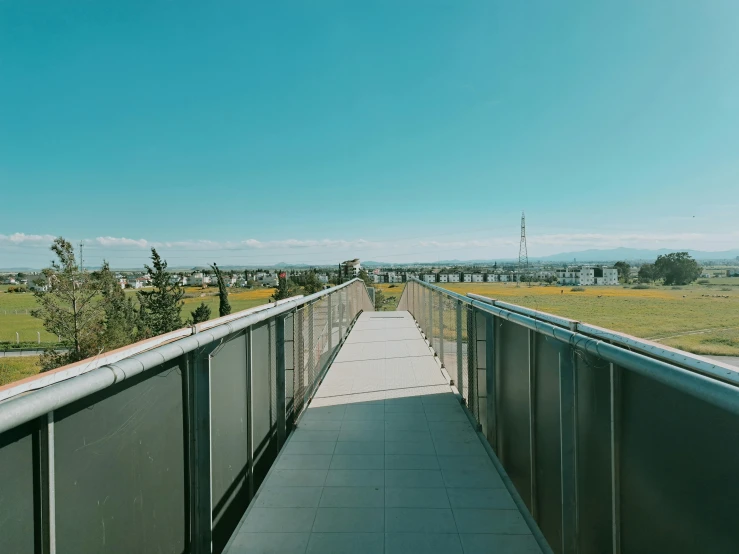 there is a tall bridge going through the field