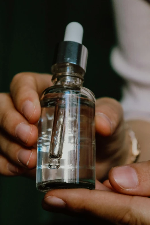 a man holding a glass and metal bottle