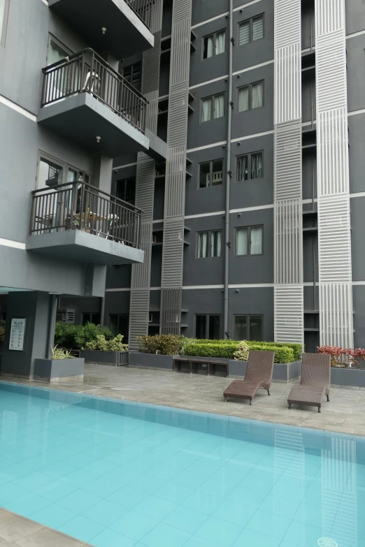 an empty pool sits in front of several apartment buildings