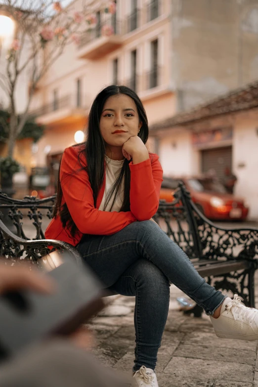 a woman sitting on a bench with her head near her hands