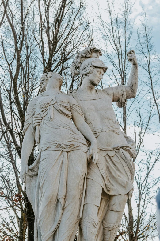 two statues are shown on the side of a tree