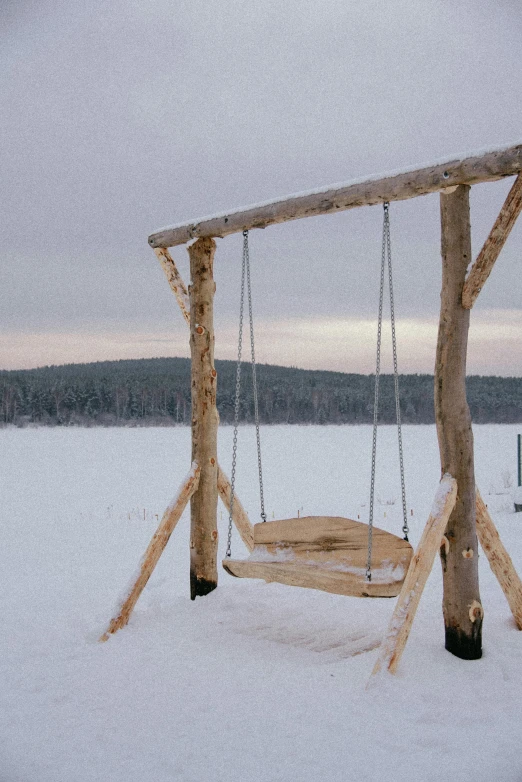 two swings sit on the snow covered ground
