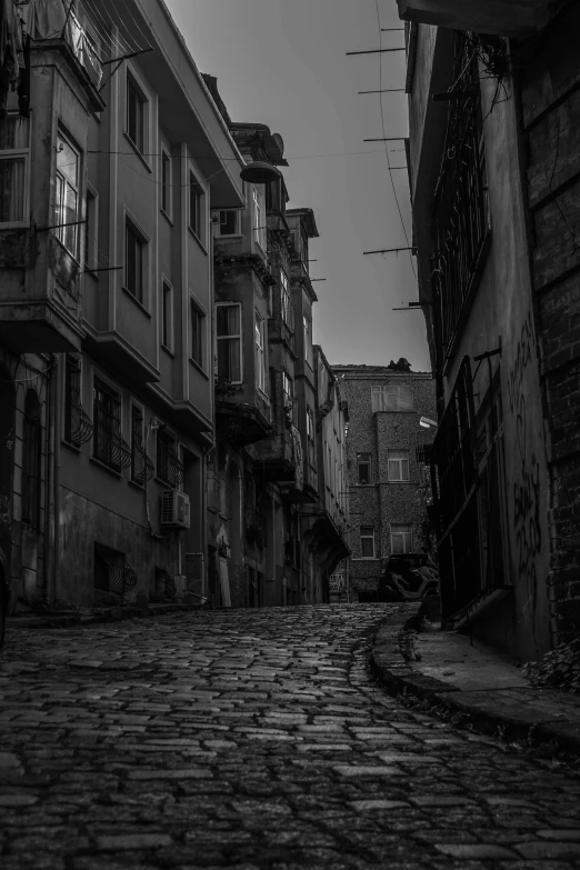 an alleyway with a clock and buildings