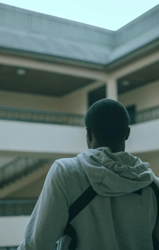 a person in a jacket looks over a building