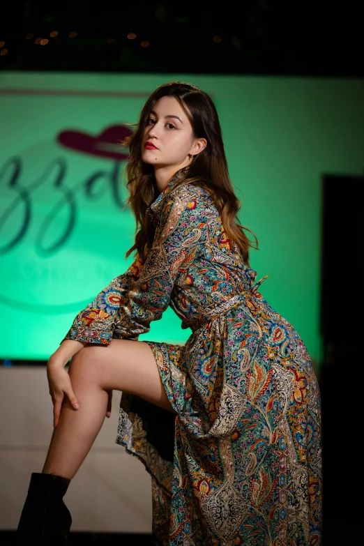 a young woman in a long dress sits on a bench