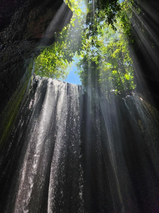 water fall with sunlight coming through the clouds