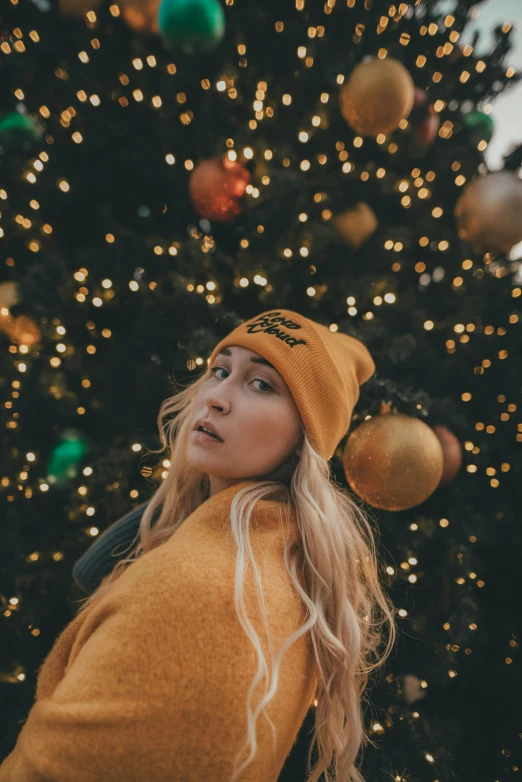 a blonde woman wearing a yellow beanie and smiling