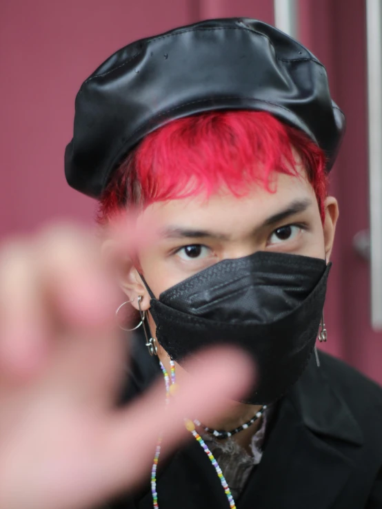a woman with pink hair wearing a black mask