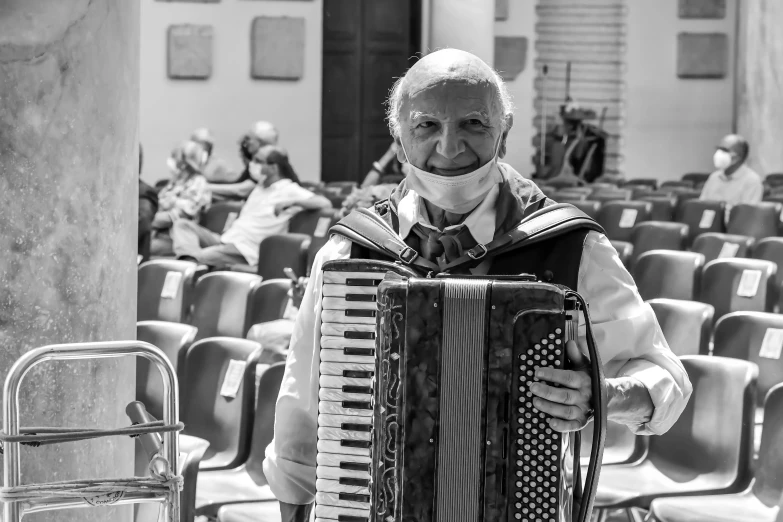 a man wearing glasses playing an accordion