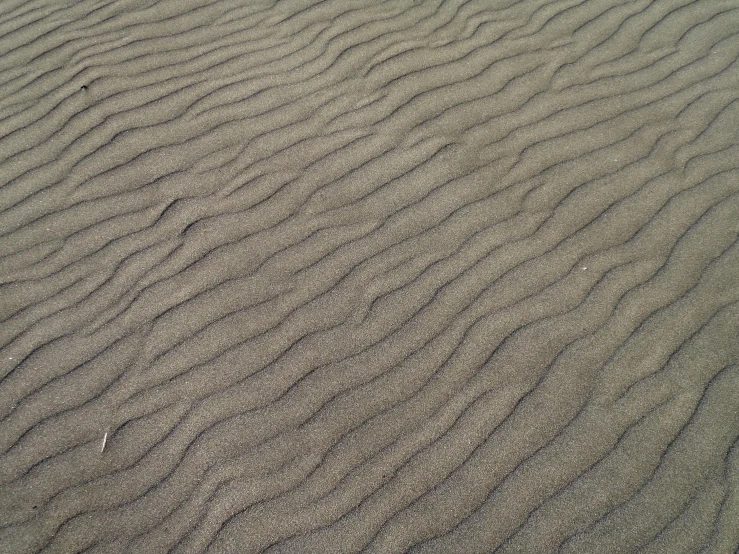 a wavy pattern of sand on a beach