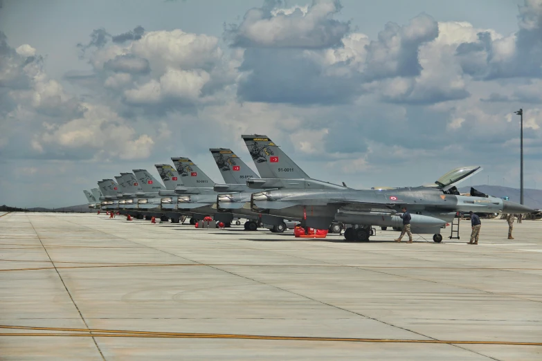 there are rows of fighter jets parked on a runway