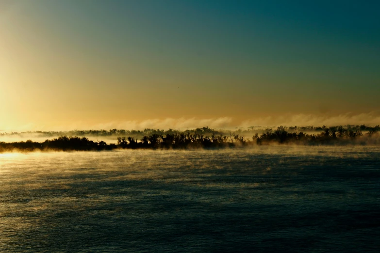 a boat floats on the water at sunrise