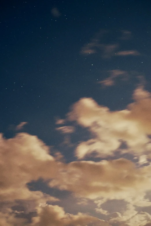 dark skies with light clouds and stars in the sky