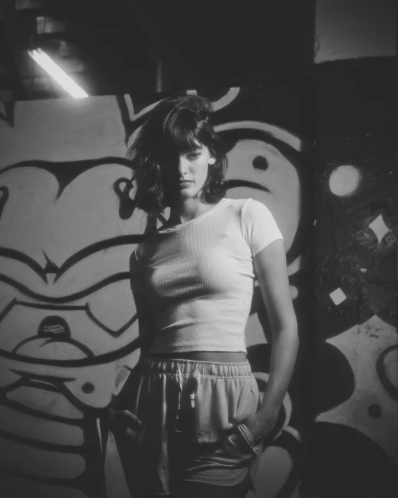 a girl stands in front of graffiti walls