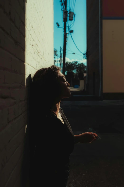 a woman standing in front of a brick wall