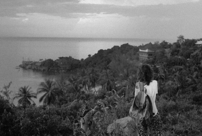 a man walks on a mountain near the ocean