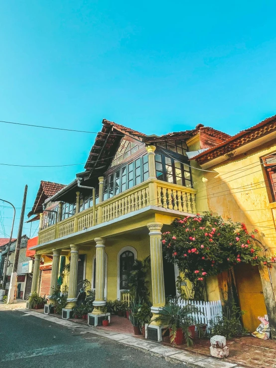 an old style house with yellow and green trim on a corner