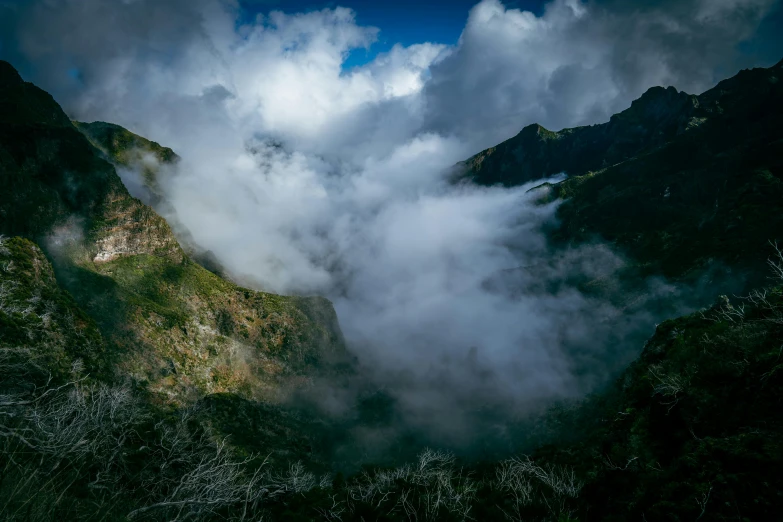 several dark mountain peaks are covered with clouds