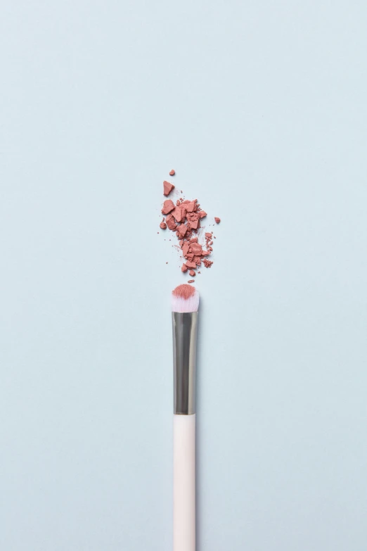 a pink powder spilling out of a white tube