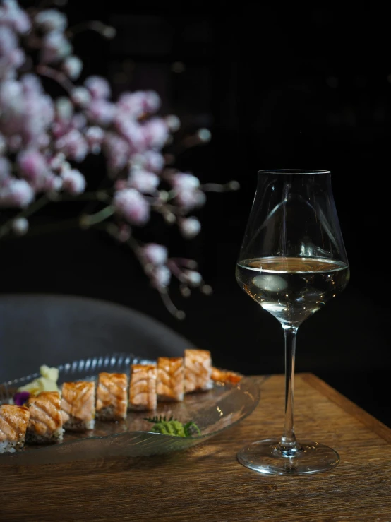 a sushi dish served with white wine on the table