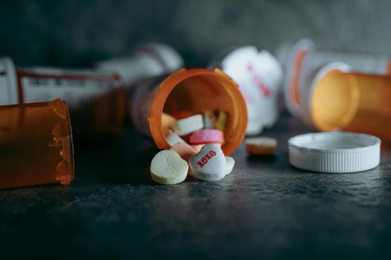 an assortment of pills and pill bottles are on the ground