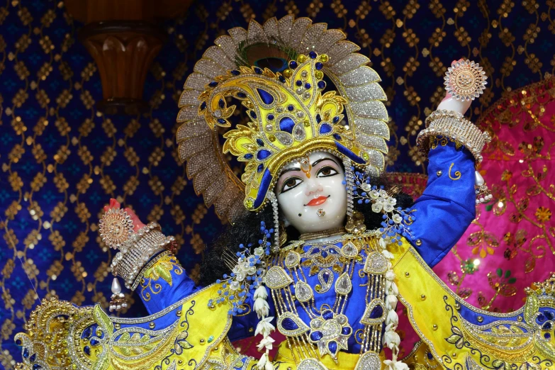 a mask dressed in brightly colored colors, holding a fan