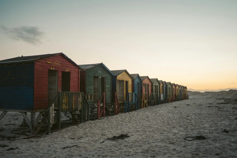 many beach huts are arranged in a line