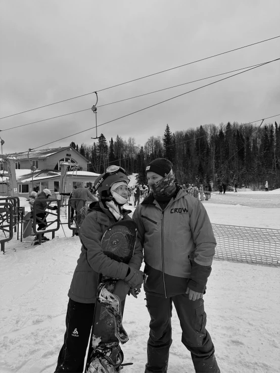 two people posing for the camera while snowboarding