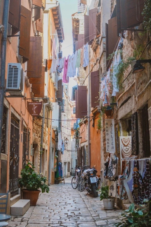 a narrow street has clothes hung from clothes lines